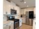 Kitchen featuring stainless steel appliances, white cabinets, and quartz countertops at 8710 Beverly Grove Ct, Las Vegas, NV 89113