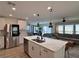 Open-concept kitchen featuring island with sink, stainless steel appliances, and adjacent living area at 8710 Beverly Grove Ct, Las Vegas, NV 89113