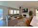 Comfortable living room with fireplace, sectional sofa, and seamless connection to the kitchen at 8710 Beverly Grove Ct, Las Vegas, NV 89113