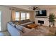 Cozy living room with a fireplace, large sectional sofa, and bright natural light at 8710 Beverly Grove Ct, Las Vegas, NV 89113