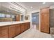 A spacious bathroom boasts dual sinks, wooden cabinets, tiled floors, and walk-in shower at 9785 Gallo Dr, Las Vegas, NV 89147