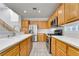 Well-lit kitchen features stainless steel appliances, wood cabinets, light countertops and tiled floors at 9785 Gallo Dr, Las Vegas, NV 89147