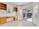 Office featuring built-in wooden cabinets, a desk, plantation shutters, and backyard access at 9785 Gallo Dr, Las Vegas, NV 89147
