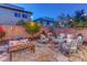 Charming backyard patio with pavers, ambient lighting, multiple seating options, and mature trees at 10422 Prairie Mountain Ave, Las Vegas, NV 89166