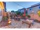 Cozy backyard patio with a warm fire pit, stone pavers, comfortable seating, and string lights at 10422 Prairie Mountain Ave, Las Vegas, NV 89166