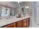 Double vanity with a large mirror and modern fixtures in a well-lit primary bathroom at 10422 Prairie Mountain Ave, Las Vegas, NV 89166