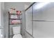 Bathroom featuring a frosted glass shower/tub, toilet, and shelving for storing toiletries at 10422 Prairie Mountain Ave, Las Vegas, NV 89166