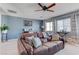 Inviting living room featuring a worn leather couch, and lots of natural light at 10422 Prairie Mountain Ave, Las Vegas, NV 89166