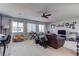 Spacious living room with plush carpet, ceiling fan, and lots of natural light from large windows at 10422 Prairie Mountain Ave, Las Vegas, NV 89166