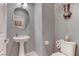 Cozy powder room features a pedestal sink, decorative mirror and modern fixtures at 10422 Prairie Mountain Ave, Las Vegas, NV 89166