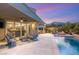 Inviting backyard showcasing a covered patio, pool, and comfortable seating around a fire pit at 10482 Calico Terrace Ave, Las Vegas, NV 89135