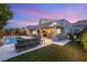 Beautiful backyard with a pool, covered patio, outdoor kitchen, and a lush lawn for relaxation and entertainment at 10482 Calico Terrace Ave, Las Vegas, NV 89135