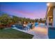 Tranquil backyard featuring a pool, lush landscaping, and cozy seating area with a fire feature at 10482 Calico Terrace Ave, Las Vegas, NV 89135