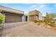 Modern home with a three-car garage, attractive brick driveway, and desert-style landscaping at 10482 Calico Terrace Ave, Las Vegas, NV 89135