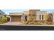 Stylish single-story home with a two-car garage, desert landscaping, and a contemporary stone accent wall at 10482 Calico Terrace Ave, Las Vegas, NV 89135