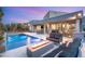 Stunning backyard oasis featuring a modern pool, spa, fire pit, and ample seating for outdoor entertaining at 10482 Calico Terrace Ave, Las Vegas, NV 89135