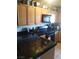 Functional kitchen with wooden cabinets, black countertops, and modern appliances at 10525 Autumn Pine Ave # 203, Las Vegas, NV 89144