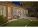 Relaxing back patio featuring a fireplace, comfortable seating, and lush landscaping at 11763 Kingsland Ave, Las Vegas, NV 89138