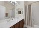 Bright bathroom features a double sink vanity, large mirror, and a shower-tub combo at 11763 Kingsland Ave, Las Vegas, NV 89138