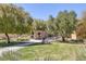 Community park featuring a stone structure, walking paths, lush grass, and mature trees at 11763 Kingsland Ave, Las Vegas, NV 89138