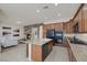 Modern kitchen with granite countertops, dark appliances, central island with sink, and open layout to living room at 11763 Kingsland Ave, Las Vegas, NV 89138