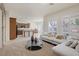 An open-concept living room and kitchen with natural light, plush sofa, tile and carpet flooring at 11763 Kingsland Ave, Las Vegas, NV 89138