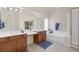 Bright bathroom with double sinks, soaking tub, vanity area, and framed glass shower at 11763 Kingsland Ave, Las Vegas, NV 89138
