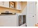 Functional laundry room with modern washer and dryer, upper cabinets and white walls at 1253 Country Club Dr, Laughlin, NV 89029
