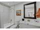 Elegant bathroom features a tub with shower, modern vanity, and a decorative mirror at 1575 W Warm Springs Rd # 1124, Henderson, NV 89014