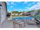 Spacious backyard with sparkling pool, lush lawn, covered patio, and stylish outdoor seating area at 1594 Pontine Ct, Henderson, NV 89052