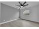 Empty bedroom featuring gray walls, modern ceiling fan, wood flooring, and a bright window with ample natural light at 1594 Pontine Ct, Henderson, NV 89052