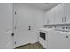 Neat laundry room with modern washer and dryer, and built-in white cabinetry at 1594 Pontine Ct, Henderson, NV 89052