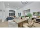Bright, open living room area featuring a large wooden table with access to the living and kitchen areas at 1594 Pontine Ct, Henderson, NV 89052