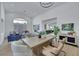 Bright, open living room area featuring a large wooden table with access to the living and kitchen areas at 1594 Pontine Ct, Henderson, NV 89052