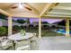 Relaxing covered patio dining area with view of the backyard featuring landscaped lawn and sparkling pool at 1594 Pontine Ct, Henderson, NV 89052