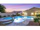 Backyard pool and spa with elegant landscaping and a covered patio, perfect for relaxing and entertaining at 1594 Pontine Ct, Henderson, NV 89052