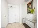 Clean, bright hallway with tile flooring, console table, art, and a solid white door with modern hardware at 200 W Sahara Ave # 3312, Las Vegas, NV 89102