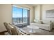 Bright living room with comfortable seating, neutral tones, and a large window offering panoramic city views at 200 W Sahara Ave # 3312, Las Vegas, NV 89102