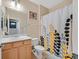 Bright bathroom with light wood vanity and a patterned shower curtain at 2091 Waterton Rivers Dr, Henderson, NV 89044