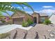 Inviting single-story home with desert landscaping, a two-car garage, and an arched entry way provides great curb appeal at 2091 Waterton Rivers Dr, Henderson, NV 89044
