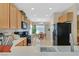 Well-appointed kitchen with natural wood cabinets and black appliances open to the dining area and great natural light at 2091 Waterton Rivers Dr, Henderson, NV 89044