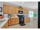 Spacious kitchen featuring tile floors, natural wood cabinets, modern black appliances, and white countertops at 2091 Waterton Rivers Dr, Henderson, NV 89044