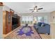 Cozy living room with a ceiling fan, lots of light, and a large rug perfect for relaxing and entertaining at 2091 Waterton Rivers Dr, Henderson, NV 89044