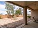 This backyard features mature trees, a rock garden, and a covered patio seating area at 2180 Tiger Links Dr, Henderson, NV 89012