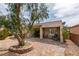 Spacious backyard featuring a covered patio with seating, mature trees, and rock landscaping at 2180 Tiger Links Dr, Henderson, NV 89012