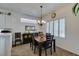 Bright dining area featuring a dark wood table, chandelier, and plantation shutters at 2180 Tiger Links Dr, Henderson, NV 89012