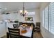 Elegant dining area featuring a stylish chandelier and adjacent kitchen with bright white cabinets at 2180 Tiger Links Dr, Henderson, NV 89012