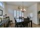 Warm dining room with a dark wood table, modern chandelier, and plantation shutters at 2180 Tiger Links Dr, Henderson, NV 89012