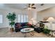 Cozy living room with plush black leather furniture, a ceiling fan and plantation shutters for natural light at 2180 Tiger Links Dr, Henderson, NV 89012
