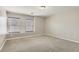 A bright bedroom with neutral colored walls and carpet, featuring two large windows at 224 Pioneers Peak Ave, Henderson, NV 89002